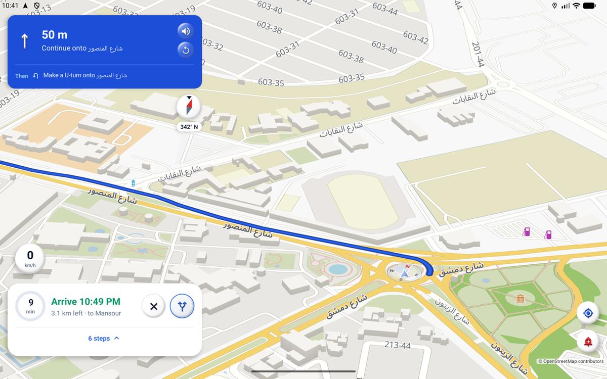 Wend on a tablet, navigating in Baghdad: the next turn in a blue card at the top, the route as a blue line between 3D buildings, and the arrival time at the bottom.
